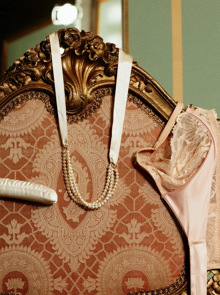White hanger, jewelry, bra and underwear hanging over upholstered furniture